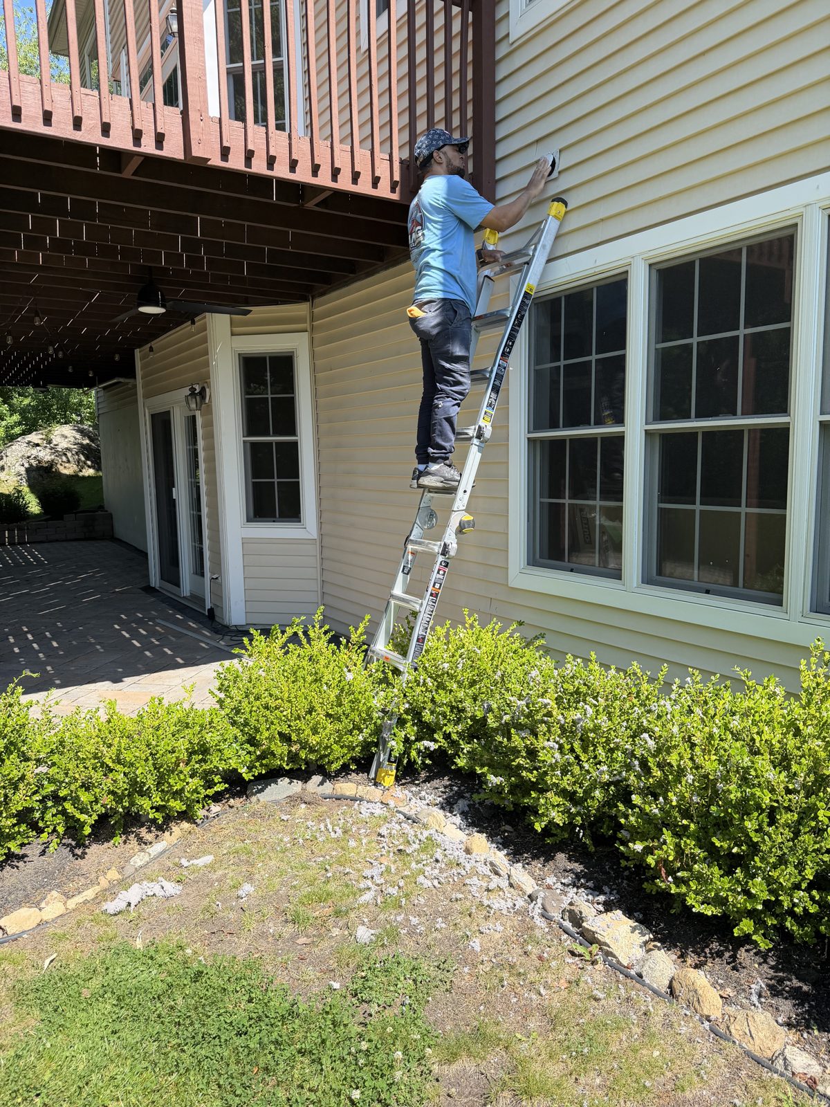 An AMG technician on a ladder at a New Jersey home