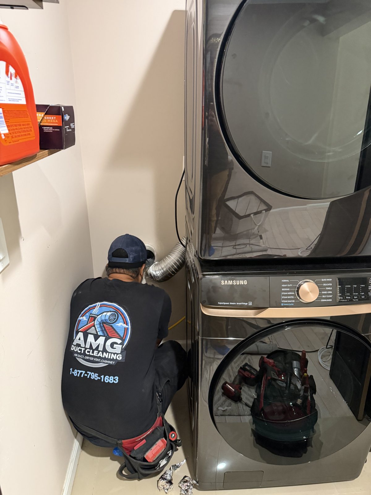 An AMG technician servicing a dryer in a New Jersey home